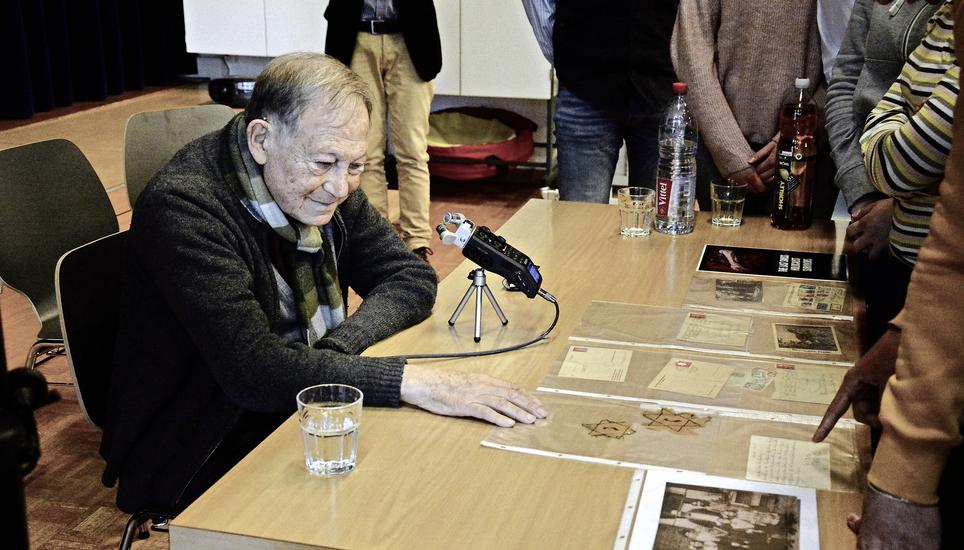 Nach seinem Vortrag zeigt Salomon den Schülern zahlreiche Postkarten, Bilder und Briefe, die er aus der Kriegszeit aufbewahrt hat. Bild: Fabienne Niederer