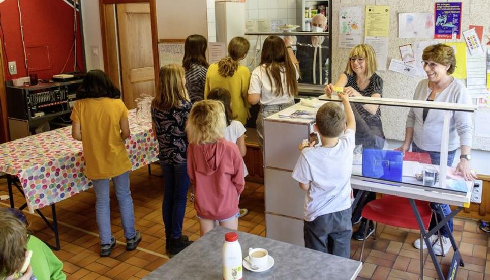 Der Mittagstisch im Jugendlokal B45 ist auch wegen der familiären Atmosphäre, die seine Begründerin, Ruth Bancroft (l., hinter der Theke), und ihr Team verbreiten, bei den Eltern und Schulkindern sehr beliebt. Bild: Michael Kessler