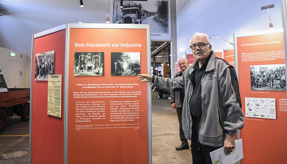 Kurator Ernst Willi (vorne) und Stiftungsratspräsident Martin Huber führen die Besucher durch die neue Ausstellung auf dem SIG-Areal in Neuhausen. Bild: Melanie Duchene