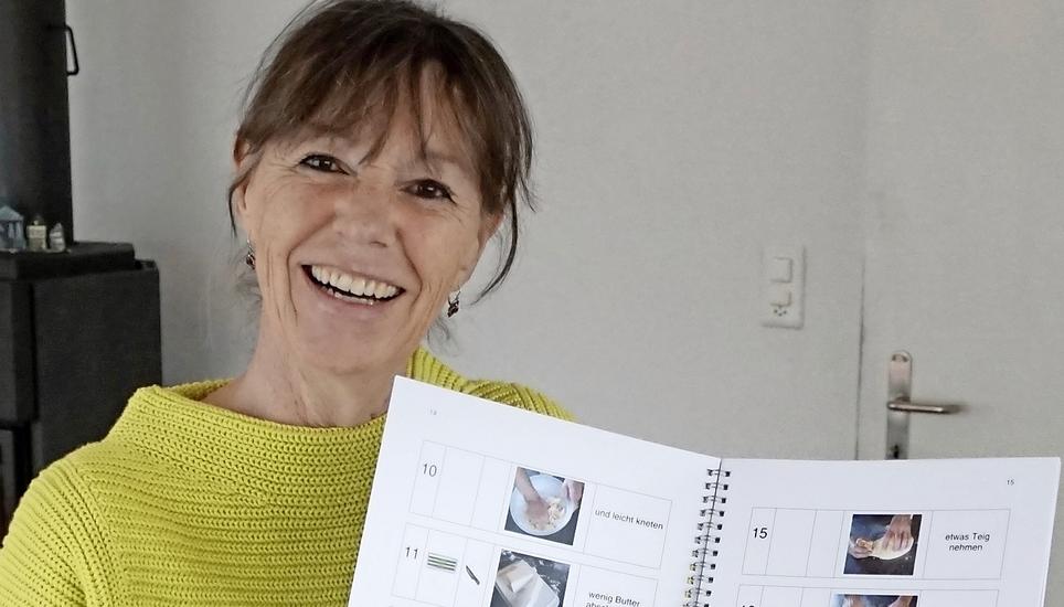 Gaby Marghitola mit einem Teil ihres Kochbuchs. Bild: Karin Lüthi Graf