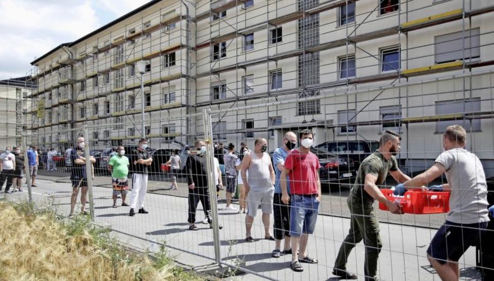 Eingesperrt: Mitarbeiter des Fleischverarbeitungsunternehmens Tönnies, welche sich unter Quarantäne befanden, erhalten Ende Juni bei einem Wohnblock im Bezirk Suerenheide im deutschen Verl Lebensmittelvorräte. Bild: Key