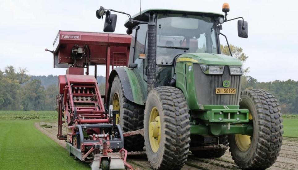 Der Traktor von Bauer Rolf Fehr vom Rhyhof in Flaach, hier von Sohn Stefan gefahren, beim Schneiden des Rafzer Rollrasens. Zum Zug kommt eine Spezial-Erntemaschine aus den Niederlanden.