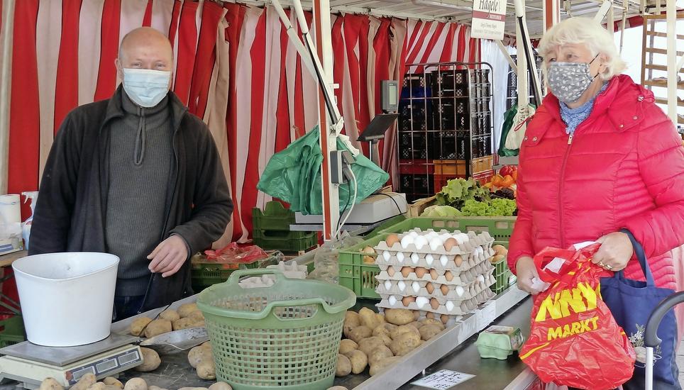 Seit die Infektionszahlen in die Höhe schnellen, gilt für den Händler Thomas Hägele und seine Kunden auf dem Singener Wochenmarkt wieder Maskenpflicht. Bild: Gudrun Trautmann