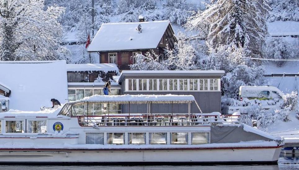 Mitarbeitende der Schifffahrtsgesellschaft URh reinigen die Schiffe vom grossen Schnee. In der Werft sind am Montag die Vorbereitungsarbeiten für die kommende Saison aufgenommen worden. Bild: Roberta Fele