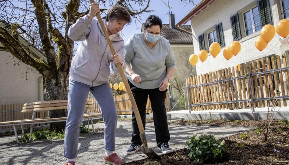 Veronika Häusermann (links) pflanzt mit einer Betreuerin weisse Rosen im Garten des «Höfli» an. Bild: Roberta Fele
