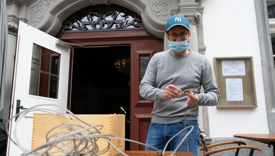 Er strahlt förmlich, während er die Tische und Stühle von den Kabeln befreit: ein Servicemitarbeiter vor der Gerberstube.
