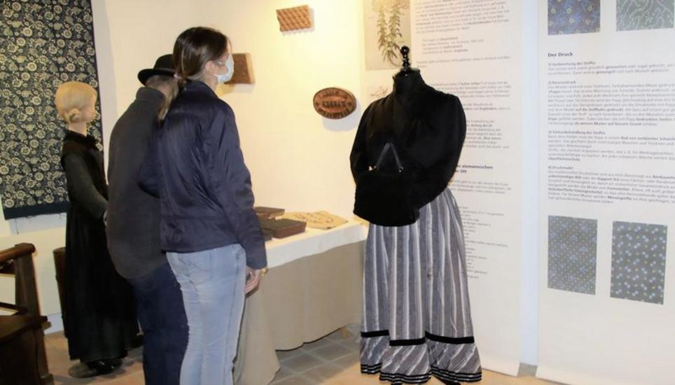 Besucher inmitten der Exponate im Ortsmuseum Marthalen, das sich dieses Jahr den Stoffen widmet. Bild: Roland Müller