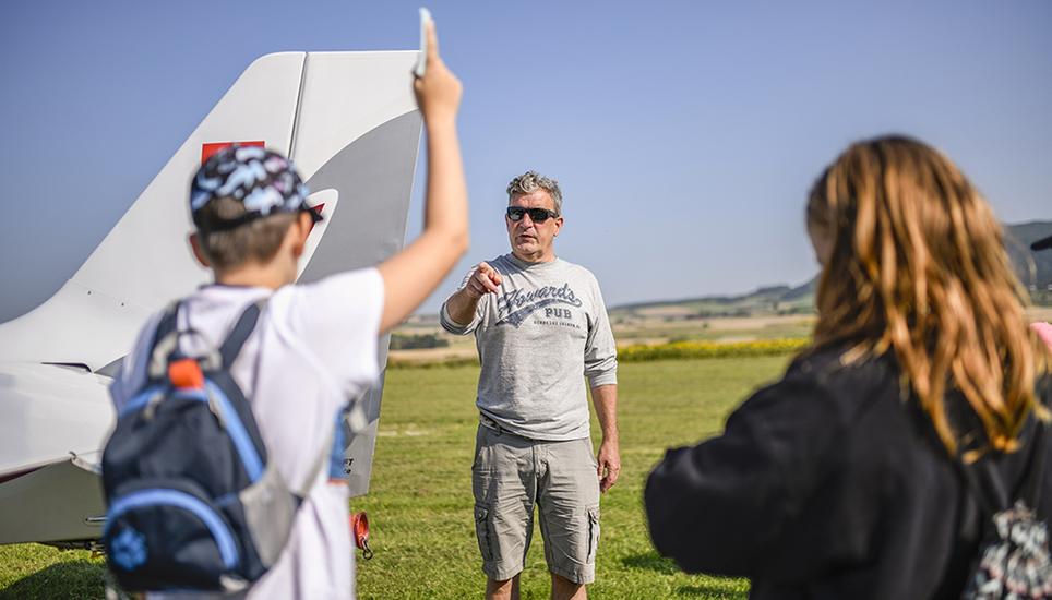 Die Kinder stehen auf dem Flugplatz Schmerlat bei Neunkirch in einem Halbkreis um eine Robin DR 400.