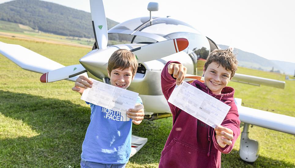Um ins Flugzeug zu steigen, wird den Kindern von Hand ein Flugticket ausgestellt, das später dem Piloten Andreas Hunziker abzugeben ist.