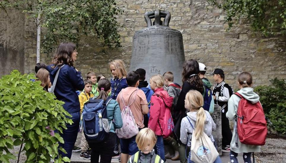 Stadtführerin Ursula Neukomm zeigt den Kindern die Schillerglocke bei der St.-Anna-Kapelle. Bild: Martina Müller