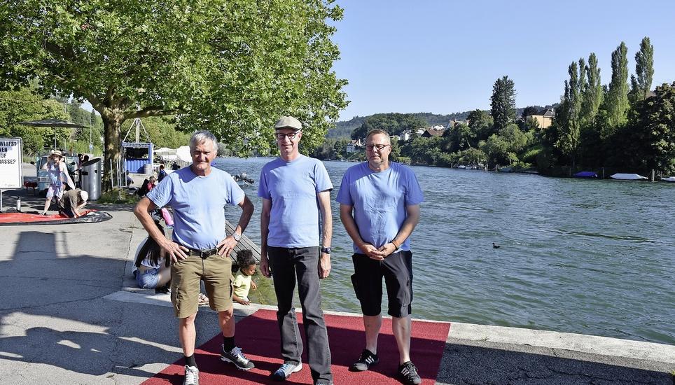 Peter Friedli (Kanuclub Schaffhausen), Peter Koch (Ruderclub Schaffhausen) und Sigi Bernath (Präsident Wassersportverband Schaffhausen, v.l.) präsentieren den neuen Teppich für den Schwimmausstieg beim Lindlischwümme vom 22. August. Bild: HCS