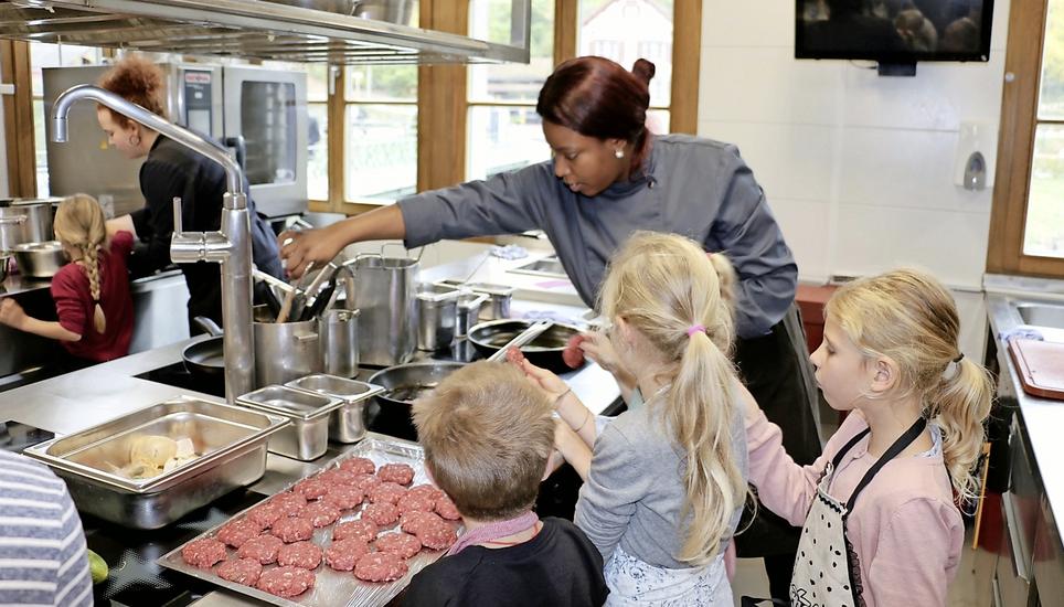 Unterstützt von Rita Ighodaro bereiten die Kinder ihre Burger zu. Bild: Liv Ira Weltzien