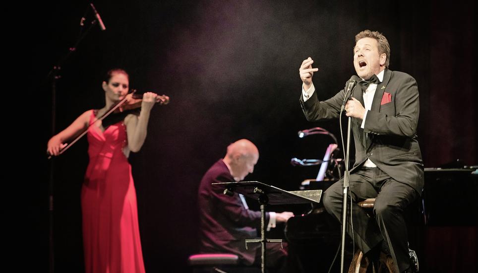 Noelle Grüebler begleitet Christian Jott Jenny bei einem seiner Lieder. Hinten in der Mitte Robert Weber, der im Laufe der Vorstellung nicht weniger als acht Instrumente spielte. Bild: Roberta Fele