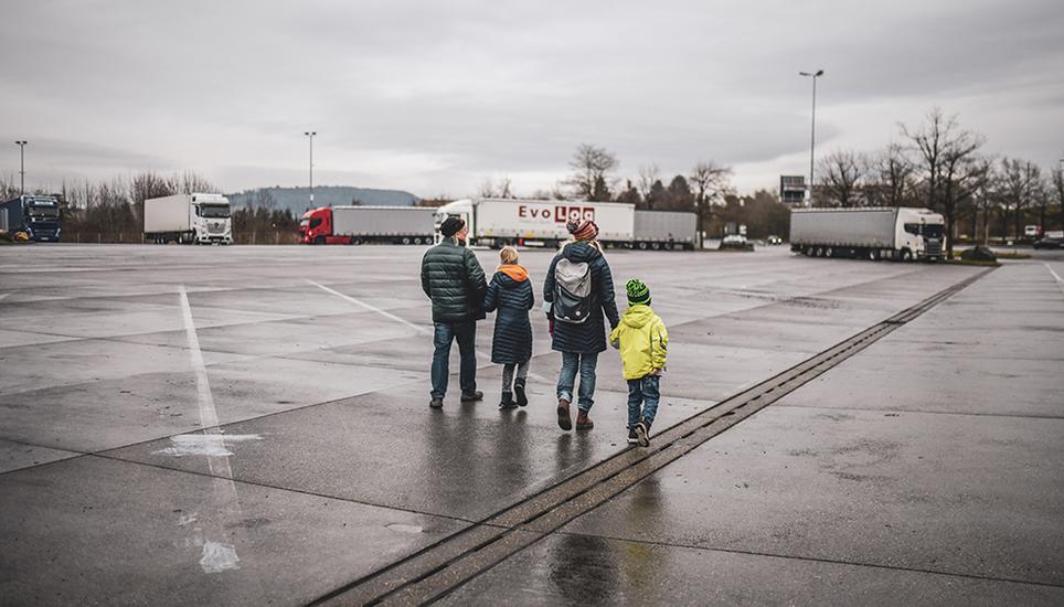 Der nass glänzende Parkplatz, wo am Nachmittag vor dem Heiligen Abend nur wenige Trucks abgestellt waren. Das Reporterteam ist auf dem Weg zu einem der litauischen Sattelschlepper. Bild: Melanie Duchene