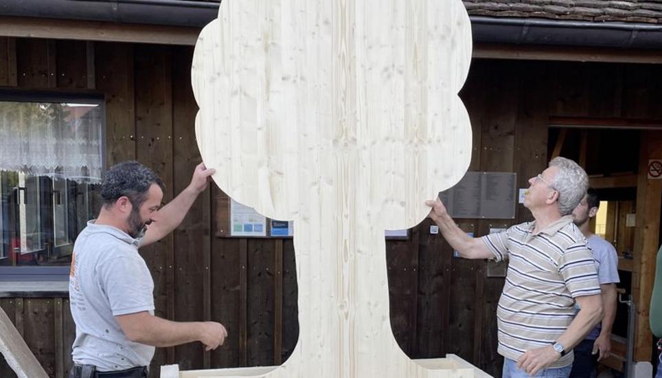 Eine Holztafel wird für das Herbstfest vorbereitet. Rechts im Bild: OK-Präsident Josef Müller. Bild: zVg