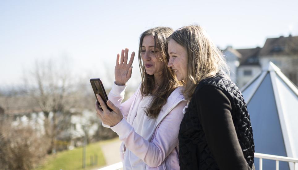 Zwei aus der Ukraine geflüchtete Frauen telefonieren mit der in der Heimat zurückgebliebenen Familie. Bild: Key