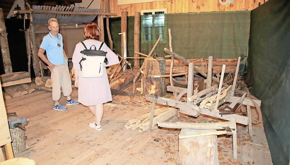 Sonderausstellung im Ortsmuseum Rafz: Ruedi Schweizer (links) von der Museumskommission und eine Besucherin vor dem Holzschlag im Dachgeschoss. Bild: RoMü