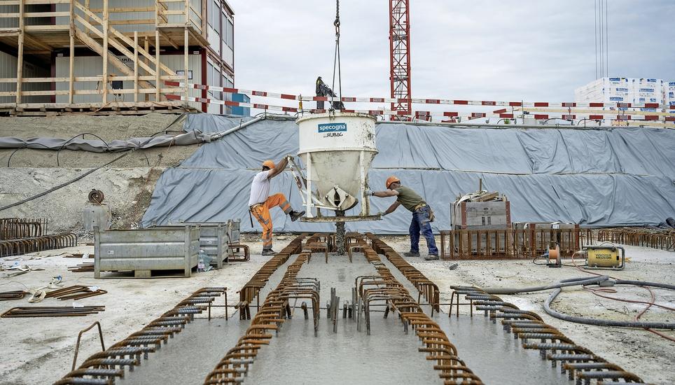 Zwei Bauarbeiter betonieren das Fundament für neu entstehende Häuser. An nicht wenigen anderen Orten fehlen solche Arbeitskräfte. Bild: Key