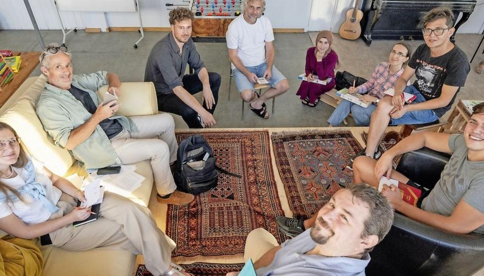 Walter Millns (2.v.l.) und Fabian Stamm (3.v.l.) leiten die Workshops, in denen Zuzüger von Neuhausen ihre Sicht auf die Stadt in Wort und Bild darstellen. Bild: Jeannette Vogel