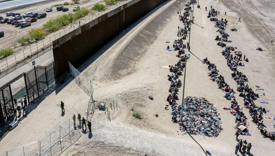 FILE - Migrants form lines outside the border fence waiting for transportation to a U.S. Border Patrol facility in El Paso, Texas, May 10, 2023. A deal to provide further U.S. assistance to Ukraine by year-end appears to be increasingly out of reach for P