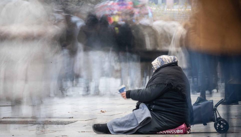 07.12.2023, Hessen, Frankfurt/Main: Mit einem Becher in der Hand bettelt eine Frau auf der Zeil in Frankfurt um etwas Kleingeld. Foto: Boris Roessler/dpa +++ dpa-Bildfunk +++ (KEYSTONE/DPA/Boris Roessler)