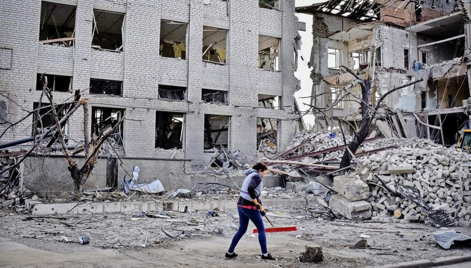 A local resident clears debris near a building damaged in the Russian air raid in the town of Orikhiv, Zaporizhzhia region, Ukraine, Friday, Apr. 5, 2024. (AP Photo/Andriy Andriyenko)