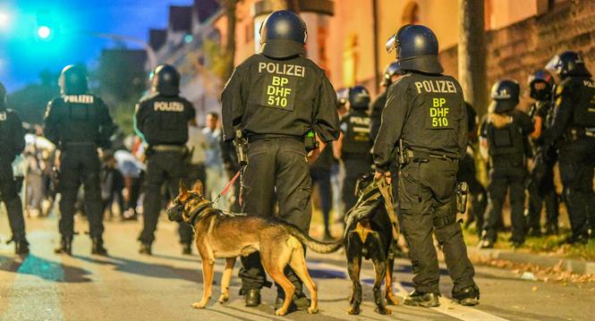 16.09.2023, Baden-WÃ¼rttemberg, Stuttgart: EinsatzkrÃ¤fte der Polizei stehen mit Hunden nach Ausschreitungen bei einer Eritrea-Veranstaltung auf der StraÃe. Bis zu 200 Personen hÃ¤tten Teilnehmer der Veranstaltung und Polizisten mit Steinen, Flas